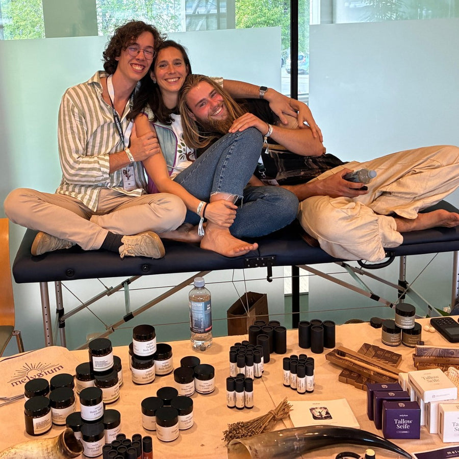 Tim und das melysium Team lachend auf dem Biohacking-Kongress in Bad Dürrheim, davor der Messetisch voller Produkte